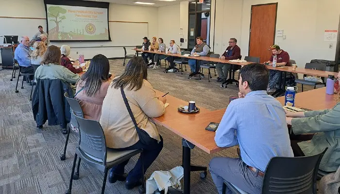 group of people sitting at tables listening to a presenter