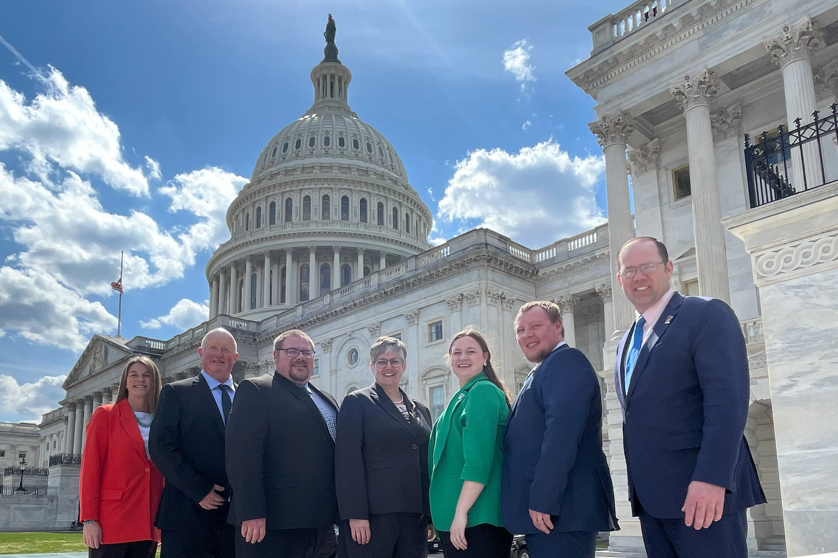 group of seven people standing in front of the capitol in Washington, DC